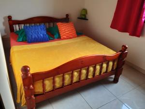 a bedroom with a wooden bed with colorful pillows at Appartement charmant à Sainte-Marie avec terrasse de 88 m² in Sainte-Marie