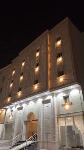 a large building with lit up windows at night at استديو الراحه in Ash Shishah