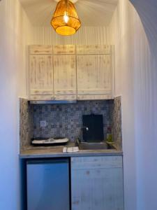 a kitchen counter with a sink and a light at Kapares Studios & Apartments in Agia Anna Naxos