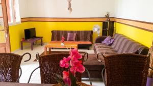 a living room with two couches and a table at Appartement Privilégié Le Moule 70 m² + Piscine in Le Moule