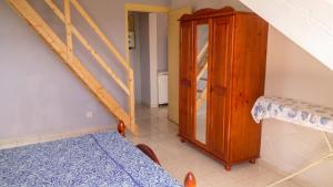 a room with a staircase and a bed and a cabinet at Appartement confortable à Capesterre, 40 m², jardin agréable in Rabi