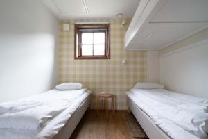 two beds in a small room with a window at Lake Cabin with Fireplace in Åre