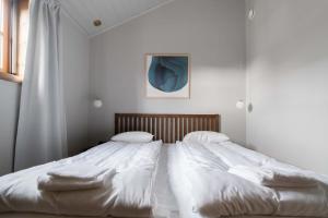 a bedroom with a large bed with white sheets and pillows at Lake Cabin with Fireplace in Åre