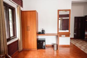 a room with a kitchen with a counter and a mirror at Apoorva River Resort in Māvingundi +6 photos