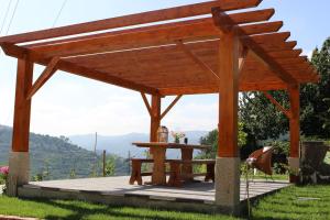 a wooden pergola with a table and a bench at Peaceful villa in São Martinho de Mouros with private pool in Frende