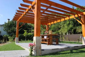 a wooden pergola with a table in a yard at Peaceful villa in São Martinho de Mouros with private pool in Frende