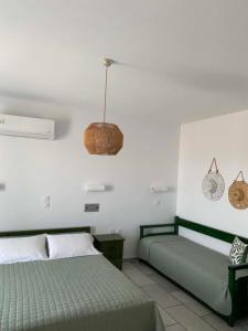 a bedroom with two beds and a pendant at Kapares Studios & Apartments in Agia Anna Naxos +15 photos