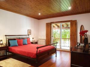 a bedroom with a bed with red sheets and a window at Elegant Villa with Panoramic Views in Caniçada in Caniçada