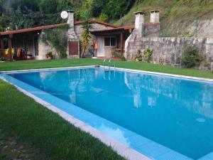 a blue swimming pool in front of a house at Elegant Villa with Panoramic Views in Caniçada in Caniçada +15 photos