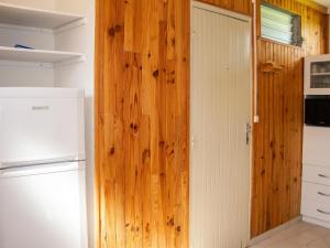 a kitchen with a wooden door and a refrigerator at Appartement de charme à Port-Louis, 35 m², jardin privé in Port-Louis