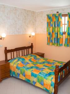 a bedroom with a bed with a colorful comforter at Appartement de charme à Port-Louis, 35 m², jardin privé in Port-Louis
