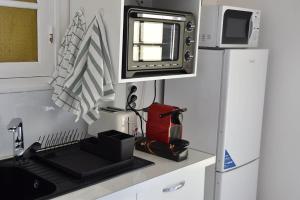 a kitchen with a sink and a microwave at Studio moderne à Baie Mahault 27 m² avec balcon agréable in Baie-Mahault