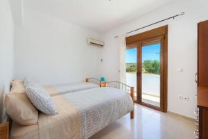 a bedroom with a bed and a sliding glass door at Cosy House in Kiotari with Garden and Terrace in Kiotari