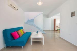 a living room with a blue couch and a white table at Cosy House in Kiotari with Garden and Terrace in Kiotari
