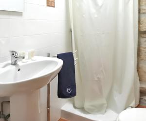 a white bathroom with a sink and a shower at Cozy house in Águeda 45 m² with shared pool in Urgueira
