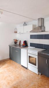 a kitchen with a white stove and a white oven at Appartement accueillant à Penne-d'Agenais - 32 m² - Terrasse in Penne-dʼAgenais