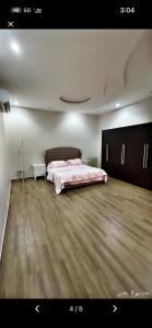 a bedroom with a bed and a wooden floor at ريفون in Tabuk