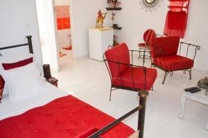 a bedroom with two red chairs and a bed at "Studio charmant à Deshaies avec piscine partagée, 20 m²" in Deshaies +4 photos