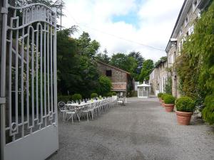 a gate with tables and chairs in a courtyard at Manoir majestueux à Satillieu avec piscine privée in Satillieu