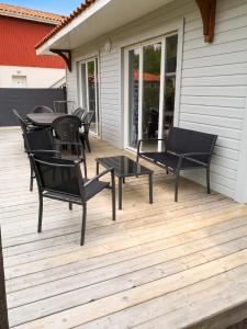 a patio with chairs and a table on a deck at Maison confortable à Parentis-en-Born avec piscine partagée in Parentis-en-Born