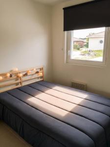 a bedroom with a large bed with a window at Maison confortable à Parentis-en-Born avec piscine partagée in Parentis-en-Born