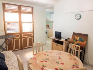 a living room with a table and a kitchen at Appartement moderne à Le Lamentin avec jardin clos, 110 m² in Le Lamentin