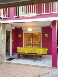 a bench on the outside of a pink building at Appartement moderne à Le Lamentin avec jardin clos, 110 m² in Le Lamentin +7 photos