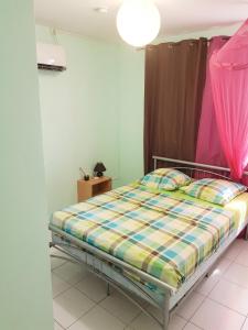 a bedroom with a bed and a pink curtain at Appartement moderne à Le Lamentin avec jardin clos, 110 m² in Le Lamentin