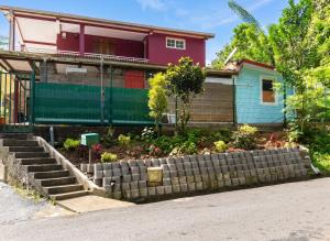 a house with a retaining wall in front of it at Appartement moderne à Le Lamentin avec jardin clos, 110 m² in Le Lamentin
