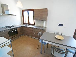 a kitchen with a table and a table and chairs at Charming House in Is Potettus with Private Garden in SantʼAnna Arresi