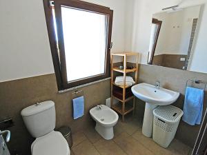 a bathroom with a toilet and a sink and a mirror at Charming House in Is Potettus with Private Garden in SantʼAnna Arresi +8 photos