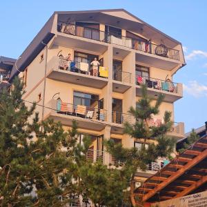 a tall building with people on balconies and trees at IVERIA BEACH in Kobuleti