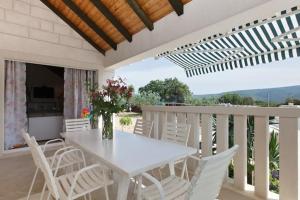a white table and white chairs on a balcony at Charming Villa in Pučišća + Pool in Pučišća +39 photos