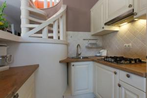 a kitchen with white cabinets and a sink at Charming Villa in Pučišća + Pool in Pučišća