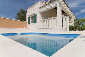 a house with a swimming pool in front of a house at Charming Villa in Pučišća + Pool in Pučišća
