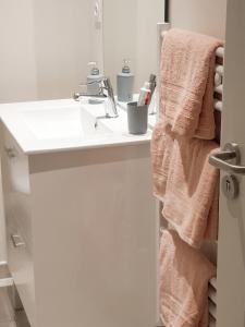 a white bathroom with a sink and towels at Charmant studio à Abondant avec terrasse ensoleillée - 30 m² in Abondant
