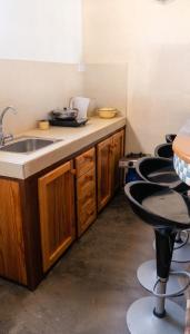a kitchen with a sink and a row of bar stools at Charming studio with sea-view terrace in Souillac - 22 m². in Souillac