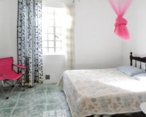 a bedroom with a bed and a red chair and a window at Spacious Apartment in Calodyne with Enclosed Garden in Calodyne