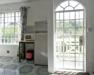 a kitchen with a refrigerator and a window at Spacious Apartment in Calodyne with Enclosed Garden in Calodyne