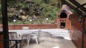 a patio with a table and chairs and a brick oven at Spacious chalet in Sibiel with mountain and lake views + Jacuzzi in Sibiel