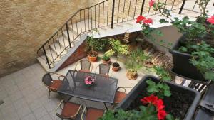 a balcony with a table and chairs and potted plants at Spacious chalet in Sibiel with mountain and lake views + Jacuzzi in Sibiel