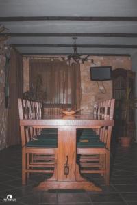 a wooden table with two chairs and a television at Spacious chalet in Sibiel with mountain and lake views + Jacuzzi in Sibiel +41 photos