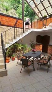 a patio with a table and chairs and stairs at Spacious chalet in Sibiel with mountain and lake views + Jacuzzi in Sibiel