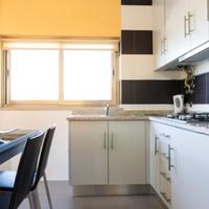 a kitchen with white cabinets and a table with chairs at Comfortable Bungalow Pinhel, pool in Pinhel