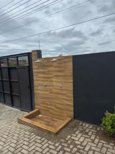 a wooden privacy fence with a black gate at Casa Completa em Picarras, Piscina, Sinuca e Churrasqueira in Piçarras