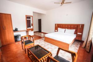 a bedroom with a bed and a table and chairs at Apoorva River Resort in Māvingundi