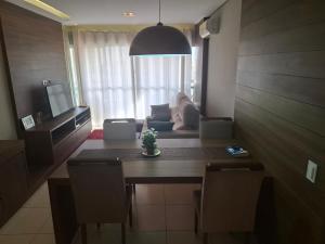 a living room with a table and a couch at Lindo quarto centro Uberlândia in Uberlândia