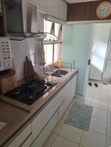 a kitchen with a sink and a stove top oven at Lindo quarto centro Uberlândia in Uberlândia