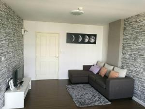 a living room with a couch and a tv at Bann Imm Aem Condo No.376 in Hua Hin