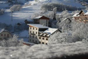 a building in the snow with snow covered trees at Appartement Douillet Saint-Sorlin-d'Arves 49 m² Vue montagne in Saint-Sorlin-dʼArves